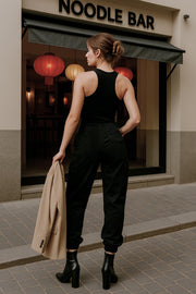 Pantalón cargo de cintura alta elástica con jareta frontal ajustable, fit amplio, plisados decorativos en rodillas, bolsillos delanteros, laterales cargo con cartera y traseros de parche. Detalle de bajo con jaretas ajustables, cierre frontal con botón y cremallera oculta.