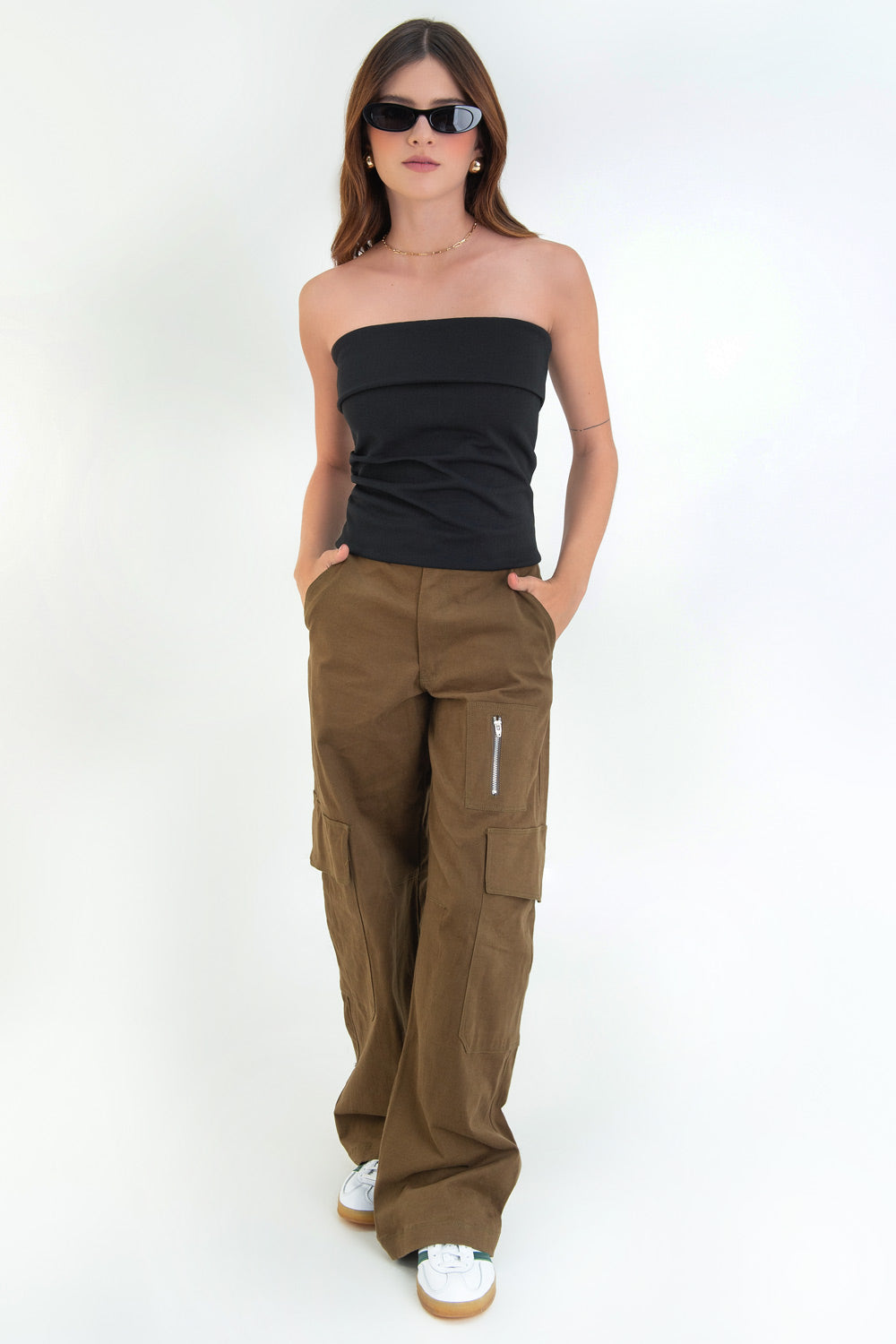 Pantalón cargo de fit wide leg, cintura media con pretina elástica posterior, trabillas, bolsillos delanteros, laterales cargo con cartera y traseros de parche. Detalle de bolsillo decorativo frontal con cremallera, cierre frontal con cremallera oculta y botón en contraste.