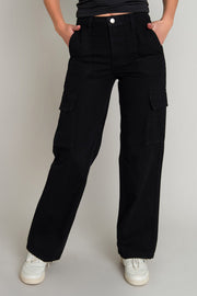 Pantalón de denim cargo de cintura alta con pretina y trabillas, fit recto, bolsillos delanteros y traseros de parche. Detalle de bolsillos laterales cargo con cartera, cierre frontal con botón y cremallera oculta. Detalle de costuras en contraste.