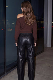 Pantalón cargo de efecto piel, fit recto, bolsillos delanteros, laterales cargo con cartera, cintura alta con pretina y trabillas. Cierre frontal con botón forrado y cremallera oculta.