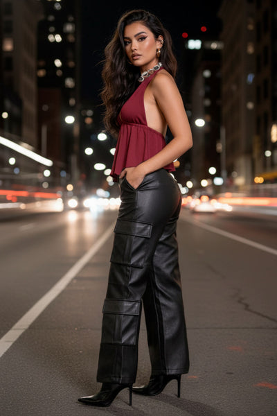 Pantalón cargo de efecto piel, fit recto, bolsillos delanteros, laterales cargo con cartera, cintura alta con pretina y trabillas. Cierre frontal con botón forrado y cremallera oculta.