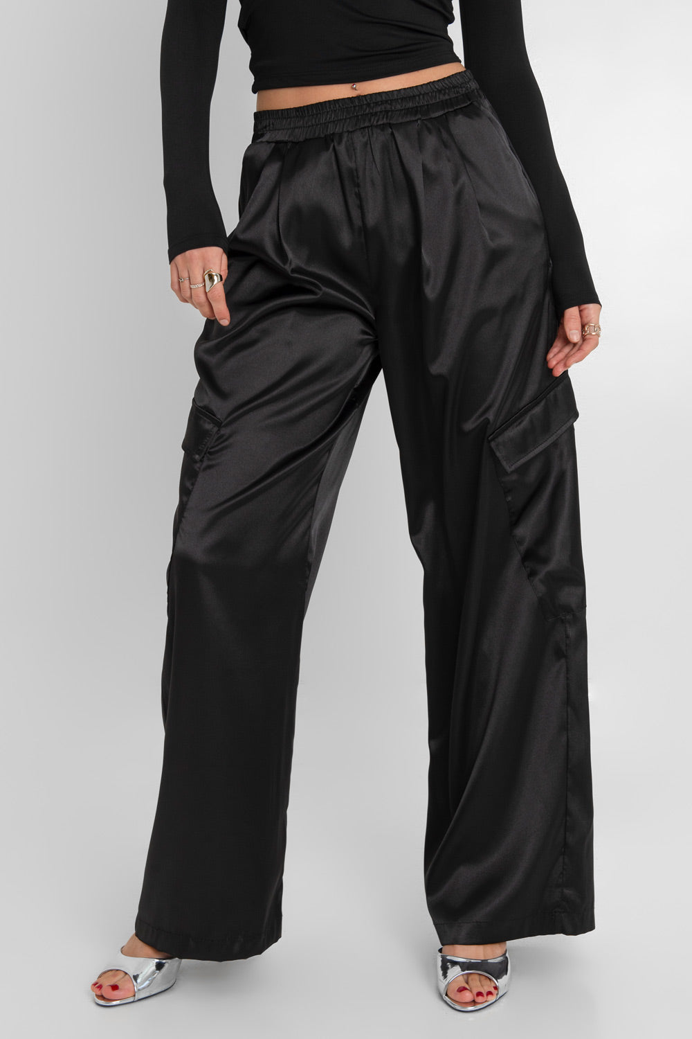 Pantalón cargo wide leg satinado de cintura alta con pretina elástica, plisados decorativos frontales, bolsillos delanteros y laterales cargo con cartera.