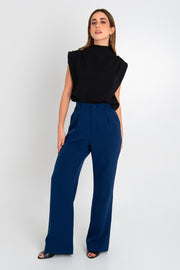 Pantalón de fit wide leg, pinzas frontales, bolsillos delanteros, cintura alta con pretina y trabillas. Detalle de vivo decorativo posterior, cierre con botón y cremallera oculta.