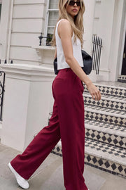 Pantalón de fit wide leg, pinzas frontales, bolsillos delanteros, cintura alta con pretina y trabillas. Detalle de vivo decorativo posterior, cierre con botón y cremallera oculta.