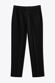 Pantalón de fit wide leg, cintura alta con pretina y trabillas, pinzas frontales, bolsillos delanteros, vivo decorativo posterior, cierre frontal con cremallera oculta y botón forrado. Detalle de raya frontal y posterior.