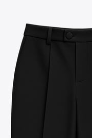 Pantalón de fit wide leg, cintura alta con pretina y trabillas, pinzas frontales, bolsillos delanteros, vivo decorativo posterior, cierre frontal con cremallera oculta y botón forrado. Detalle de raya frontal y posterior.