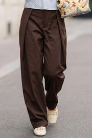Pantalón de fit barrel, cintura alta con pretina, pinzas con detalle decorativo frontal, bolsillos delanteros, cierre frontal con broche y cremallera ocultos.