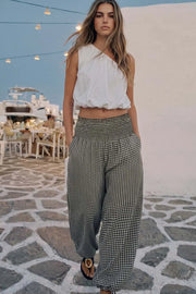 Pantalón de estampado cuadros, fit balloon, cintura alta elástica con pretina fruncida, bolsillos delanteros y bajo globo con jaretas ajustables.