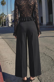 Pantalón de fit culotte, cintura alta con trabillas, raya frontal y posterior, bolsillos delanteros y vivo decorativo posterior. Cierre frontal con broche y cremallera ocultos.