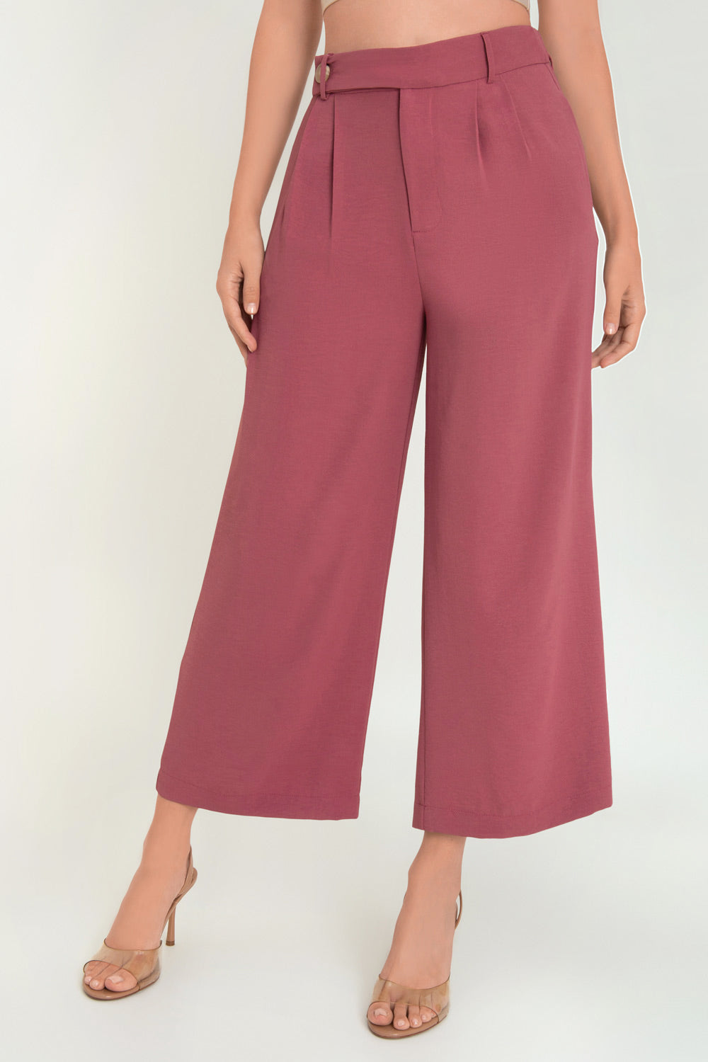 Pantalón de fit culotte, cintura alta con pretina elástica posterior y trabillas, pinzas frontales, bolsillos delanteros y vivos decorativos posteriores. Cierre frontal con cremallera oculta y trabilla con botón en contraste.