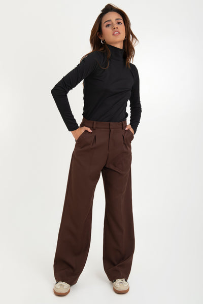 Pantalón de fit wide leg, cintura alta con pretina y trabillas, bolsillos delanteros y vivo decorativo posterior. Detalle de pinzas frontales, raya frontal y posterior, cierre frontal con broche y cremallera ocultos.