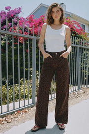 Pantalón de denim, estampado animal, fit wide leg, cintura alta con pretina y trabillas, bolsillos delanteros y traseros de parche. Cierre frontal con botón y cremallera oculta.