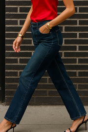 Pantalón de denim, fit recto, cintura alta con pretina y trabillas, detalle de rotos en bajo, bolsillos delanteros y traseros de parche. Cierre frontal con botón y cremallera oculta.