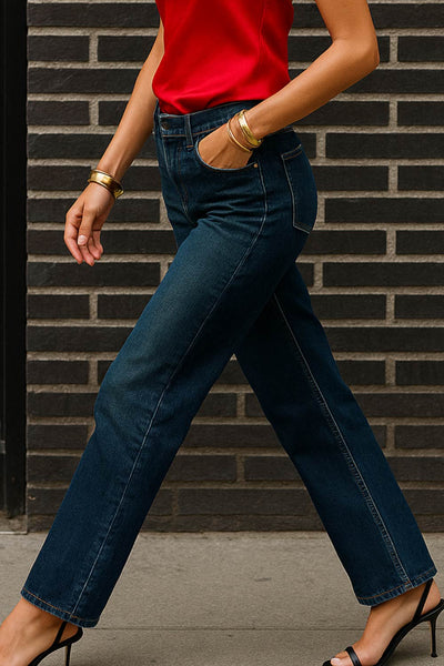 Pantalón de denim, fit recto, cintura alta con pretina y trabillas, detalle de rotos en bajo, bolsillos delanteros y traseros de parche. Cierre frontal con botón y cremallera oculta.