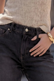 Pantalón de denim, fit baggy, cintura alta con pretina y trabillas, bolsillos delanteros y traseros de parche. Cierre con botón y cremallera oculta.