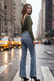 Pantalón de denim, fit flare, cintura alta con pretina y trabillas, bolsillos delanteros y traseros de parche. Cierre con botón y cremallera oculta.