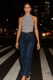 Pantalón de denim, fit flare, cintura alta con pretina, trabillas, bolsillos delanteros y traseros de parche. Cierre frontal con botón y cremallera oculta. Detalle de rotos en bajo.