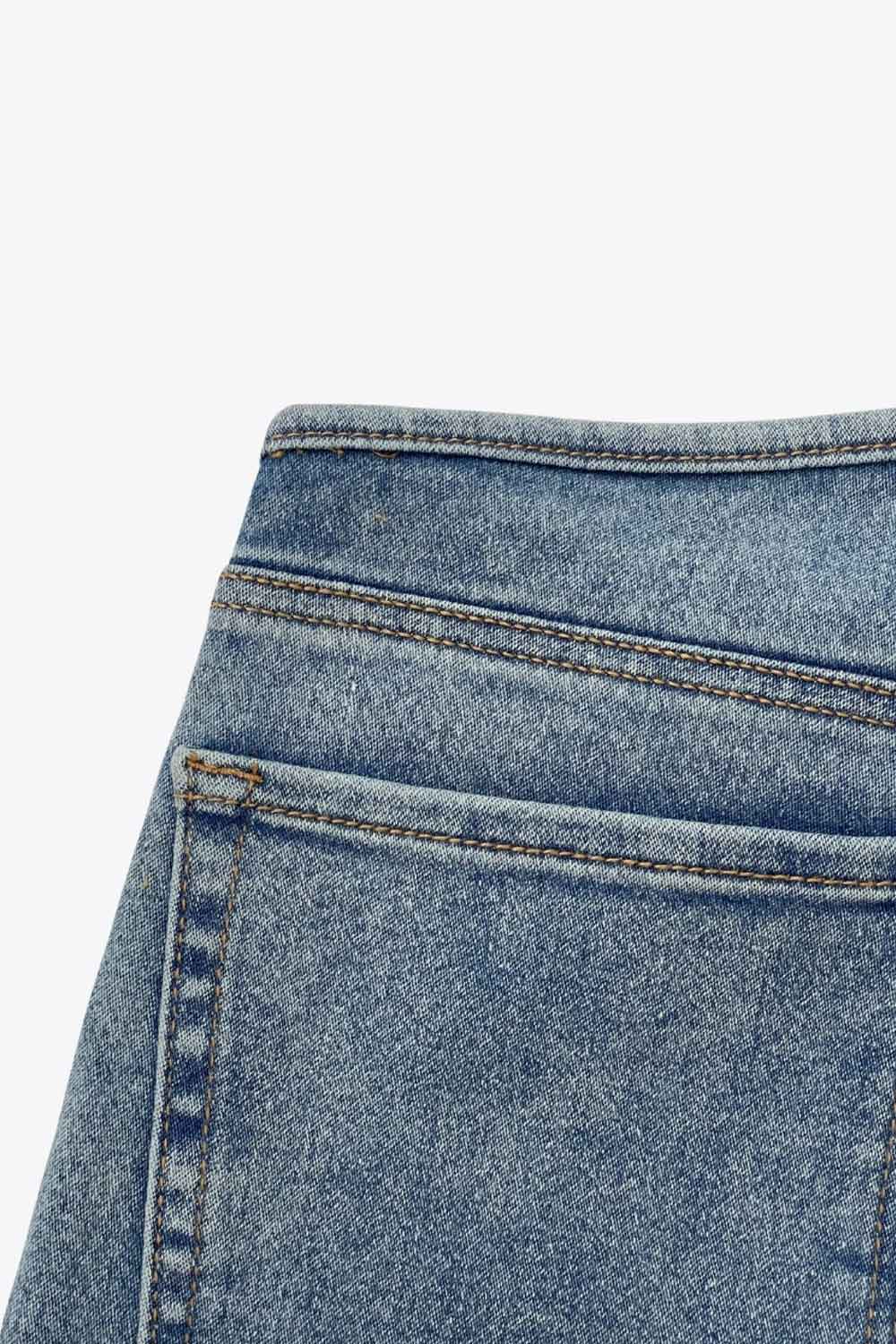 Pantalón de denim, fit recto, cintura alta, pinzas frontales, bolsillos delanteros y traseros de parche. Cierre con botón y cremallera oculta.
