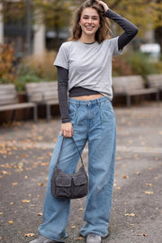 Pantalón wide leg de denim, cintura alta con pretina y trabillas, pinzas frontales, bolsillos delanteros, cierre frontal con botón y cremallera oculta.