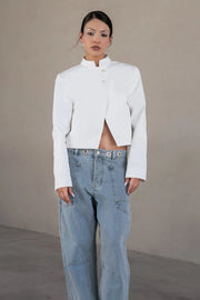 Pantalón de denim, fit barrel, cintura media con pretina y trabillas, bolsillos delanteros y traseros de parche, cierre frontal con botón y cremallera oculta. Detalle de ojillos y costuras decorativas en contraste.
