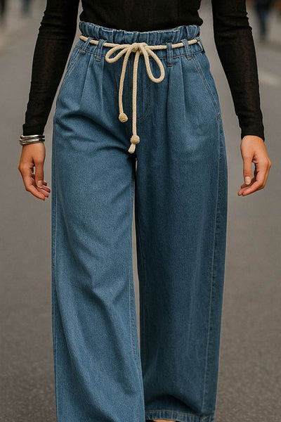 Pantalón de denim, fit wide leg, cintura alta con pretina elástica y trabillas, pinzas frontales, jareta frontal en contraste, bolsillos delanteros y traseros de parche. Cierre frontal con cremallera oculta.
