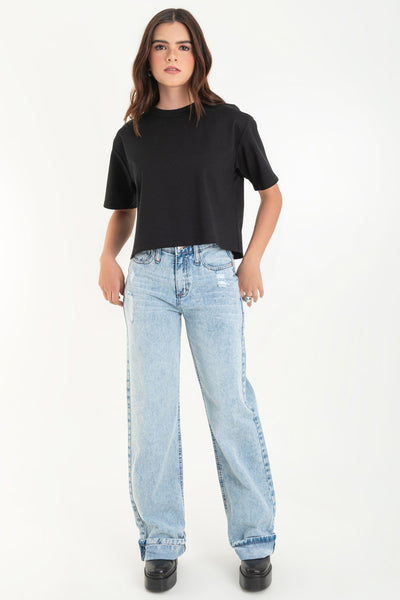 Pantalón de denim, fit wide leg, cintura alta con pretina y trabillas, bolsillos delanteros y traseros de parche. Cierre frontal con botón y cremallera oculta. Detalle de rotos y doblez en bajo.