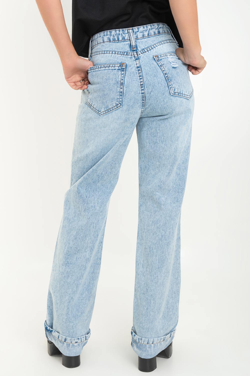 Pantalón de denim, fit wide leg, cintura alta con pretina y trabillas, bolsillos delanteros y traseros de parche. Cierre frontal con botón y cremallera oculta. Detalle de rotos y doblez en bajo.