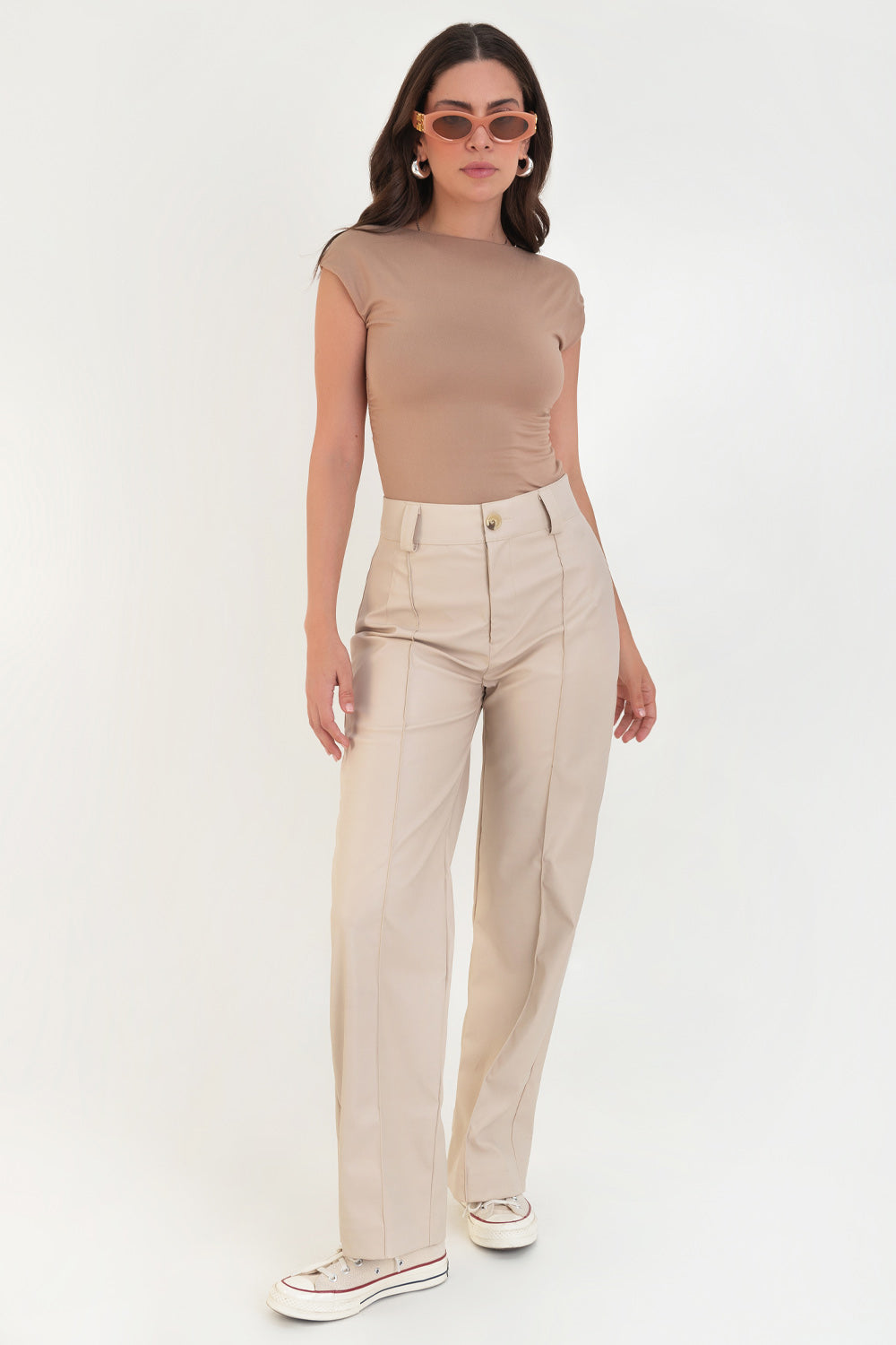 Pantalón de efecto piel, fit wide leg, cintura alta con pretina y trabillas, detalle de raya frontal con costura y cierre frontal con botón en contraste y cremallera oculta.