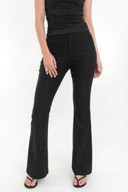 Pantalón de fit flare, cintura alta con pretina y trabillas, bolsillos delanteros y vivos decorativos posteriores. Cierre frontal con broche y cremallera ocultos.