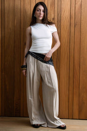 Pantalón de fit palazzo, cintura alta con pretina elástica, bolsillos delanteros y pinzas frontales.