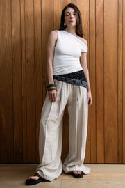 Pantalón de fit palazzo, cintura alta con pretina elástica, bolsillos delanteros y pinzas frontales.