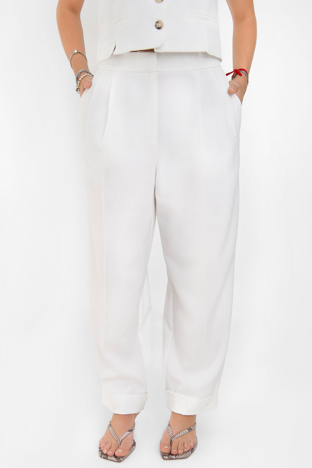 Pantalón de fit recto, cintura alta con pretina elástica posterior, pinzas frontales, bolsillos delanteros, vivo decorativo posterior y doblez en bajo. Cierre frontal con broche y cremallera ocultos.