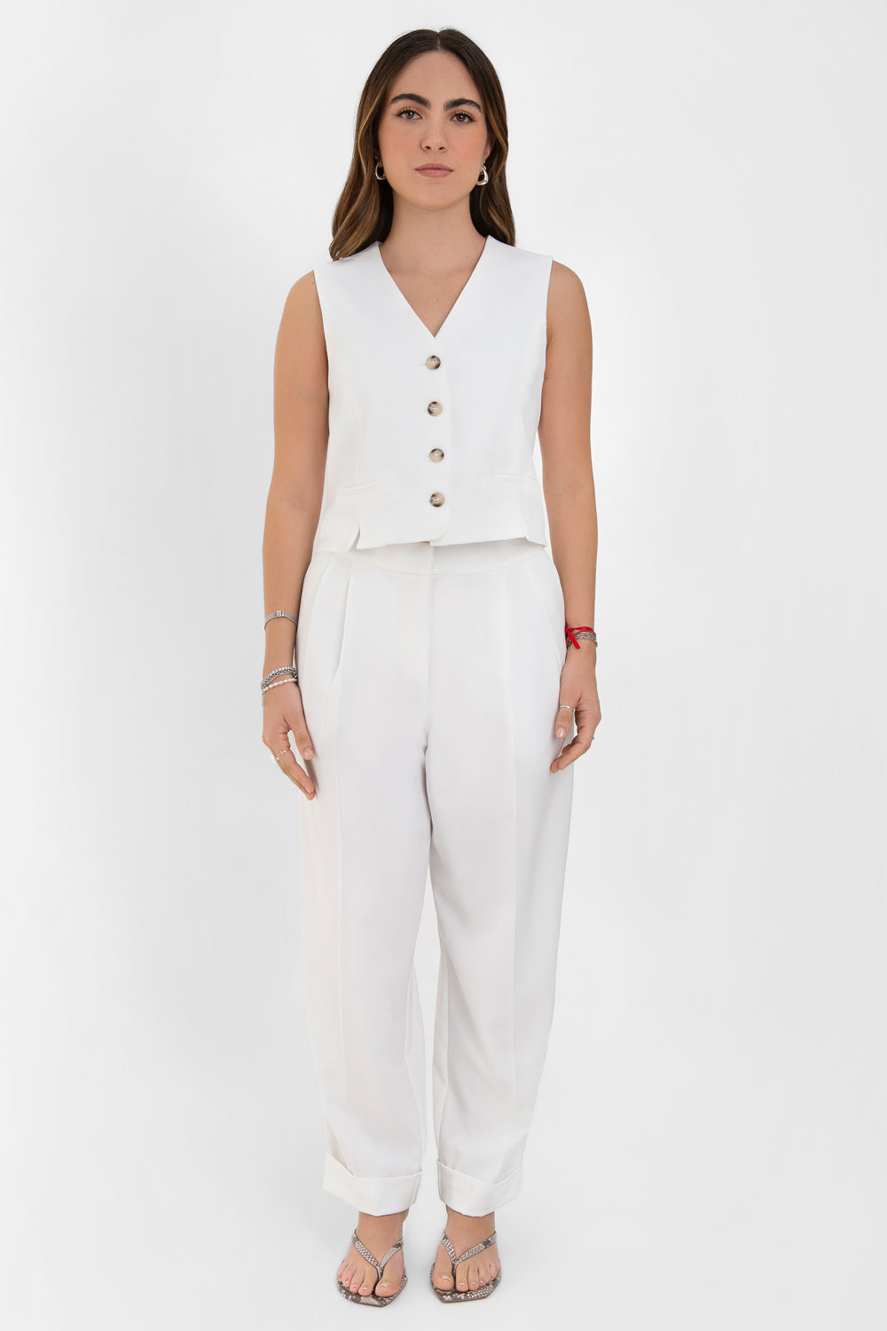 Pantalón de fit recto, cintura alta con pretina elástica posterior, pinzas frontales, bolsillos delanteros, vivo decorativo posterior y doblez en bajo. Cierre frontal con broche y cremallera ocultos.