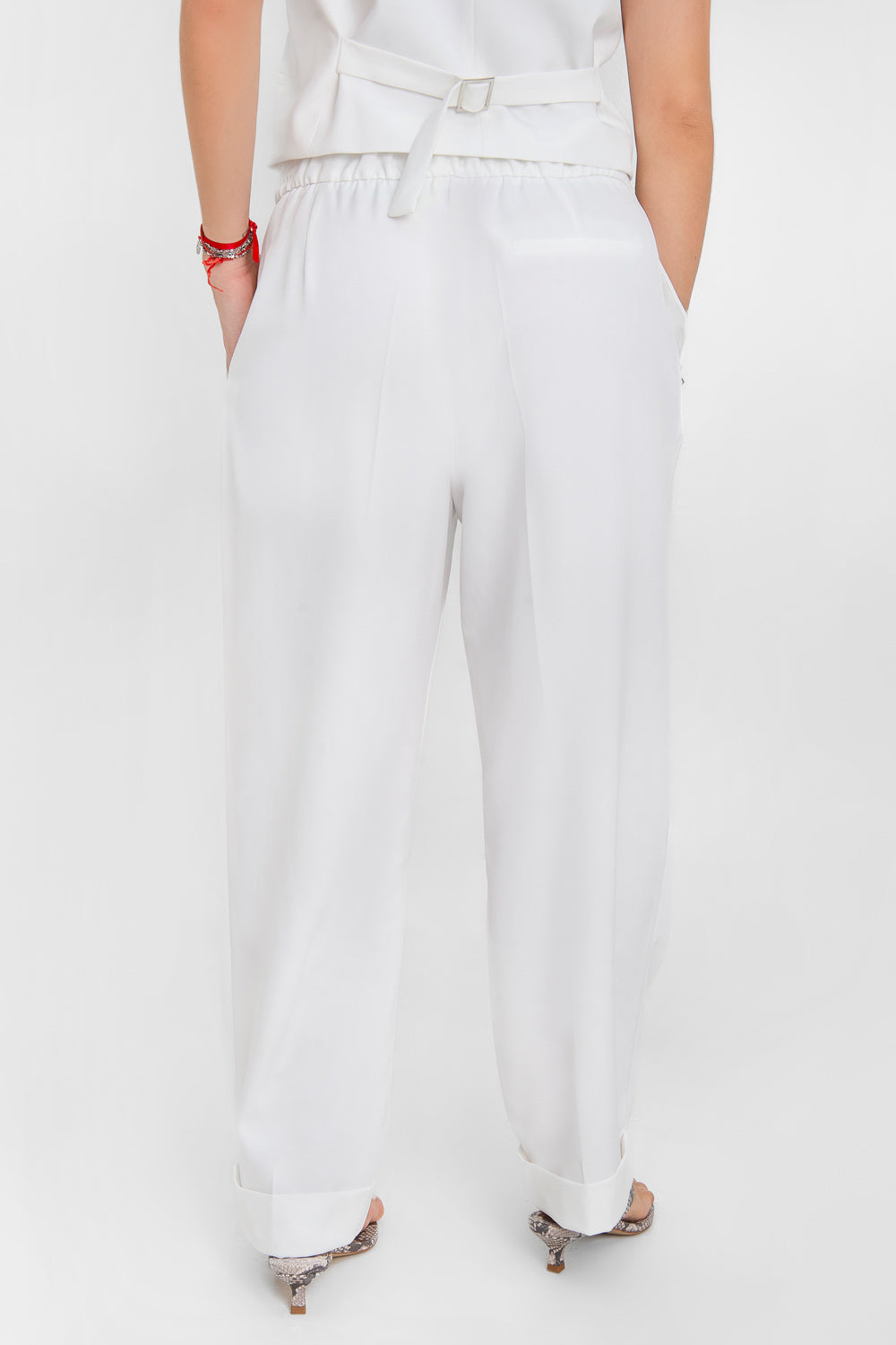 Pantalón de fit recto, cintura alta con pretina elástica posterior, pinzas frontales, bolsillos delanteros, vivo decorativo posterior y doblez en bajo. Cierre frontal con broche y cremallera ocultos.