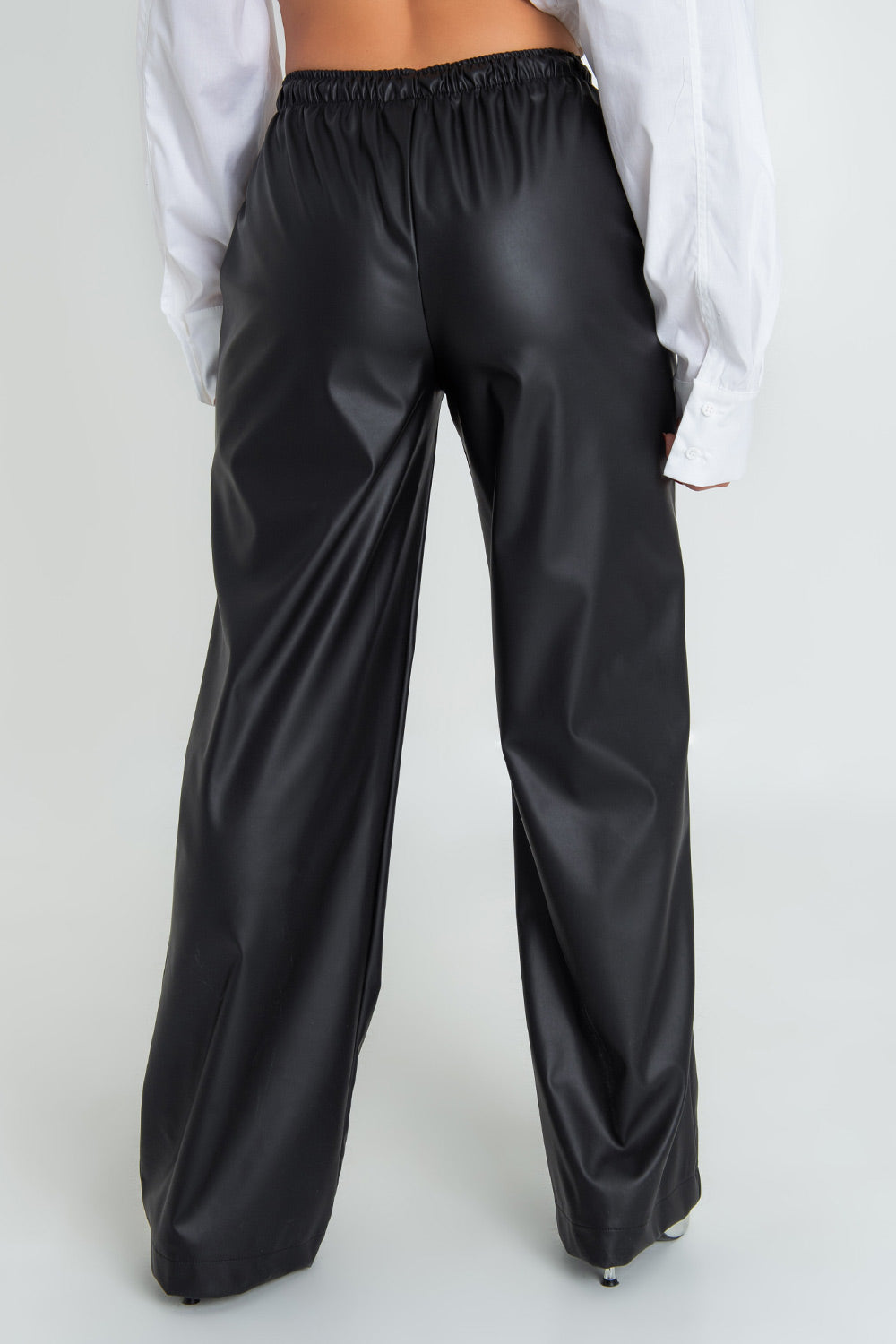 Pantalón de fit recto, efecto piel, bolsillos delanteros, cintura alta con pretina elástica y jareta frontal ajustable.