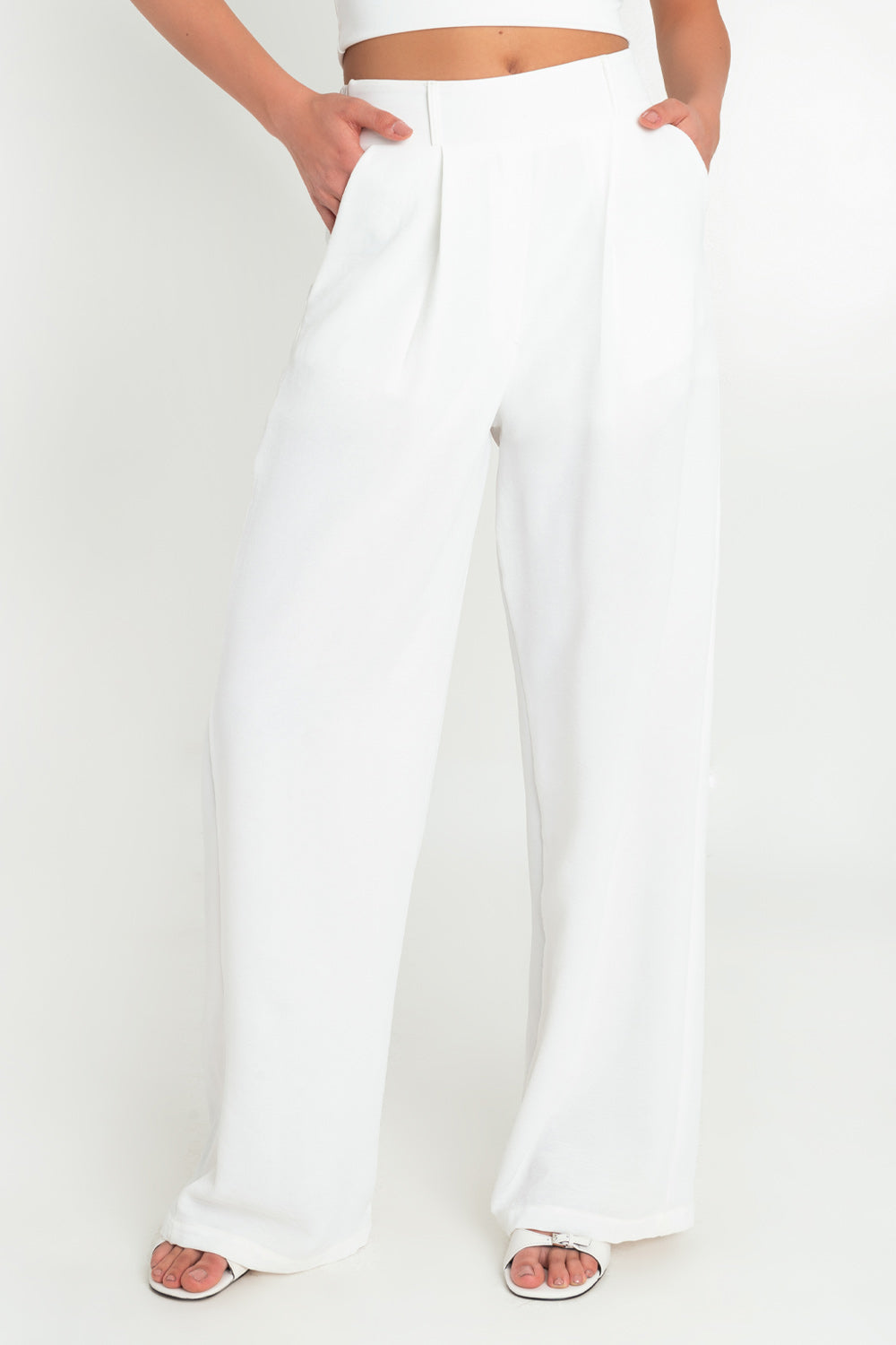 Pantalón de fit wide leg, cintura alta con pretina elástica posterior y trabillas, bolsillos delanteros y pinzas frontales.