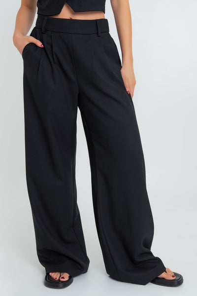 Pantalón de fit wide leg, cintura alta con pretina elástica posterior, trabillas, pinzas frontales y bolsillos delanteros.