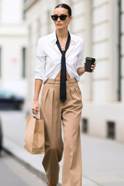 Pantalón de fit wide leg, tiro bajo, pretina con trabillas, pinzas frontales, bolsillos delanteros, detalle de raya frontal y posterior. Cierre frontal con botón y cremallera oculta.