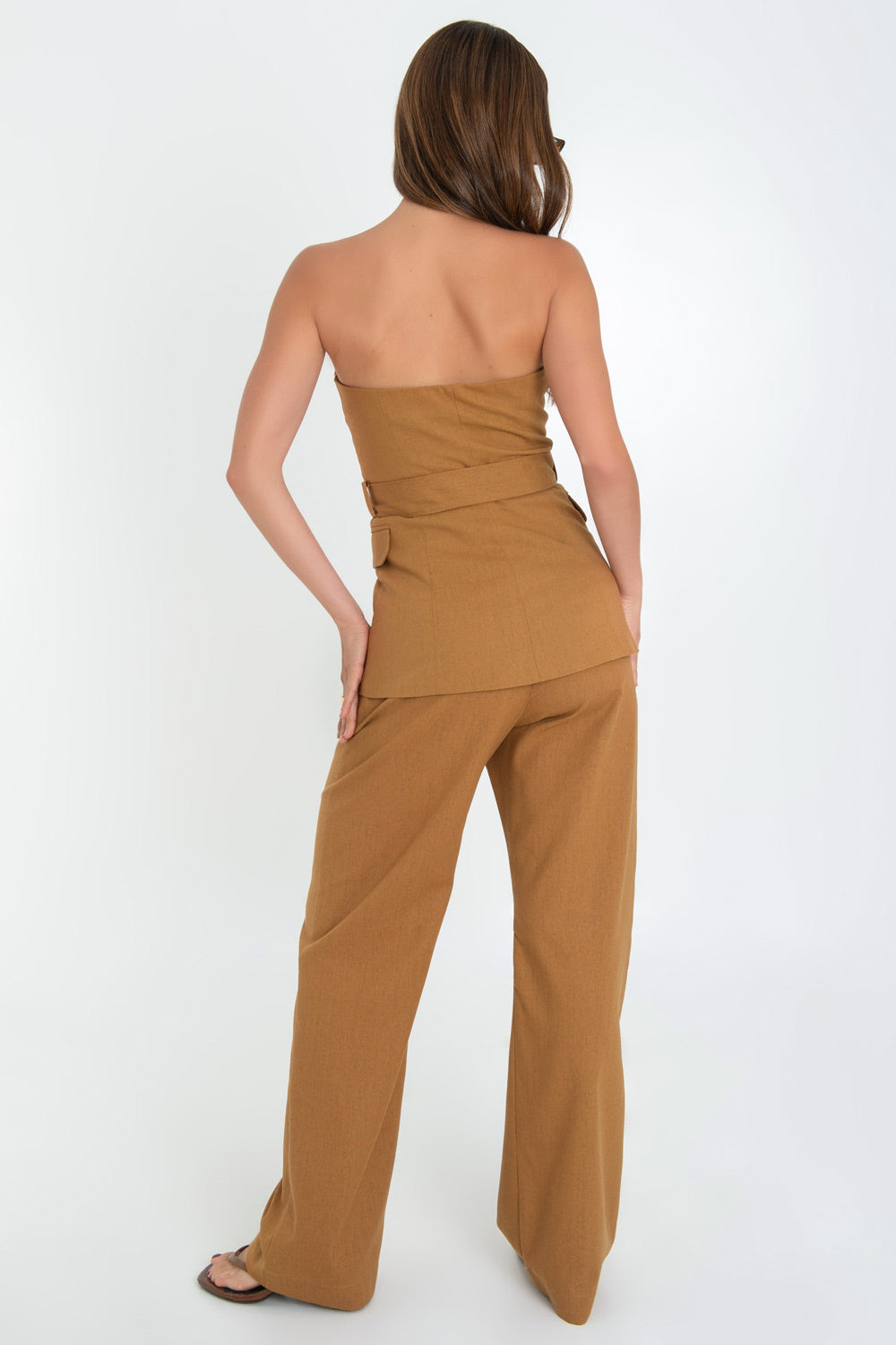 Pantalón de lino, fit wide leg con pinzas frontales, cintura alta con pretina y trabillas, bolsillos delanteros, cierre frontal con botón en contraste y cremallera oculta.