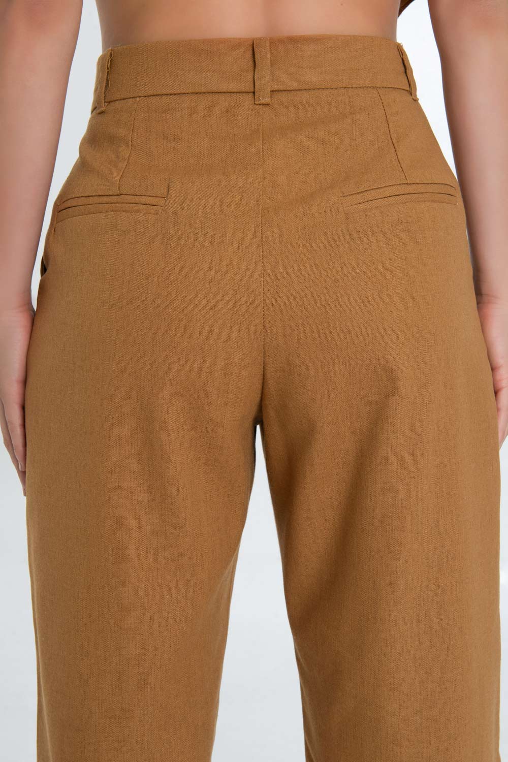 Pantalón de lino, fit wide leg con pinzas frontales, cintura alta con pretina y trabillas, bolsillos delanteros, cierre frontal con botón en contraste y cremallera oculta.