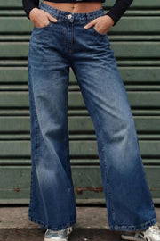 Pantalón wide leg de denim, cintura media con pretina y trabillas, bolsillos delanteros y traseros de parche con bordado de estrella. Cierre frontal con botón y cremallera oculta.