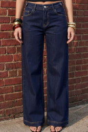 Pantalón de denim, fit recto, cintura media con pretina y trabillas, bolsillos delanteros y traseros de parche. Cierre frontal con botón y cremallera oculta. Detalle de trabillas con botón en pretina.