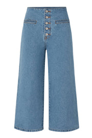 Pantalón de denim, fit cropped flare, cintura alta, vivos delanteros y bolsillos traseros de parche. Cierre frontal con hilera de botones.
