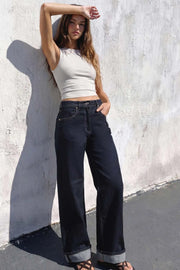 Pantalón de denim, fit recto, tiro alto, pretina con trabillas, bolsillos delanteros y traseros de parche. Cierre frontal con botón y cremallera oculta. Detalle de doblez en bajo.