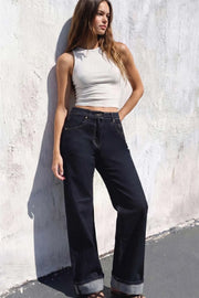 Pantalón de denim, fit recto, tiro alto, pretina con trabillas, bolsillos delanteros y traseros de parche. Cierre frontal con botón y cremallera oculta. Detalle de doblez en bajo.