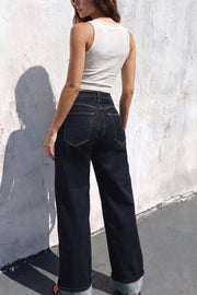 Pantalón de denim, fit recto, tiro alto, pretina con trabillas, bolsillos delanteros y traseros de parche. Cierre frontal con botón y cremallera oculta. Detalle de doblez en bajo.