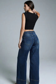 Pantalón de denim, fit wide leg, tiro alto, pretina con trabillas, bolsillos delanteros y traseros de parche. Cierre frontal con botón y cremallera oculta. Detalle de trabilla ajustable posterior.