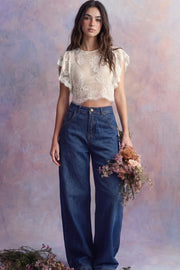 Pantalón de denim, fit wide leg, tiro alto, pretina con trabillas, bolsillos delanteros y traseros de parche. Cierre frontal con botón y cremallera oculta.