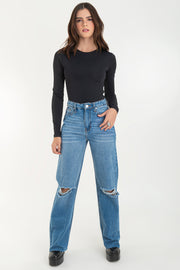 Pantalón wide leg de denim con rotos, tiro alto, bolsillos delanteros y traseros de parche. Cierre con botón y cremallera oculta. Detalle de rotos en bajo.