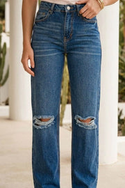 Pantalón wide leg de denim con rotos, tiro alto, bolsillos delanteros y traseros de parche. Cierre con botón y cremallera oculta. Detalle de rotos en bajo.